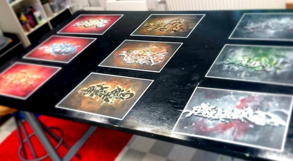 Nine graffiti related paintings spread on a table.