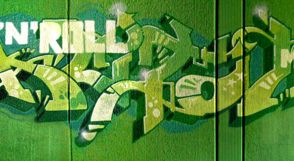 Green toned graffiti on a concrete wall.