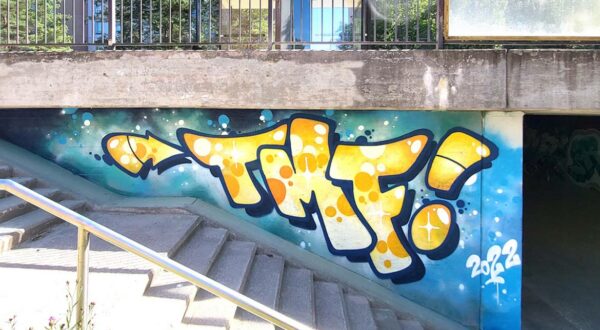 TMG graffiti on a concrete wall.