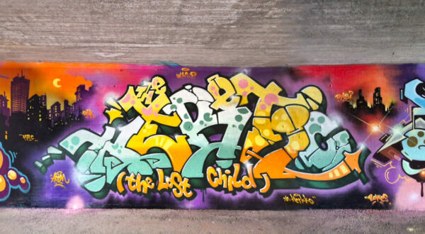 Colorful graffiti, with a cartoonlike city background.